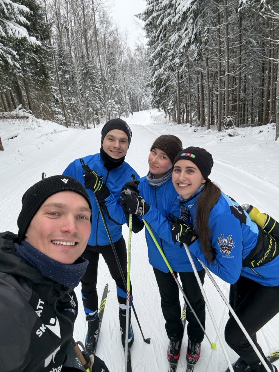 Nelja suusataja selfie lumisel metsarajal