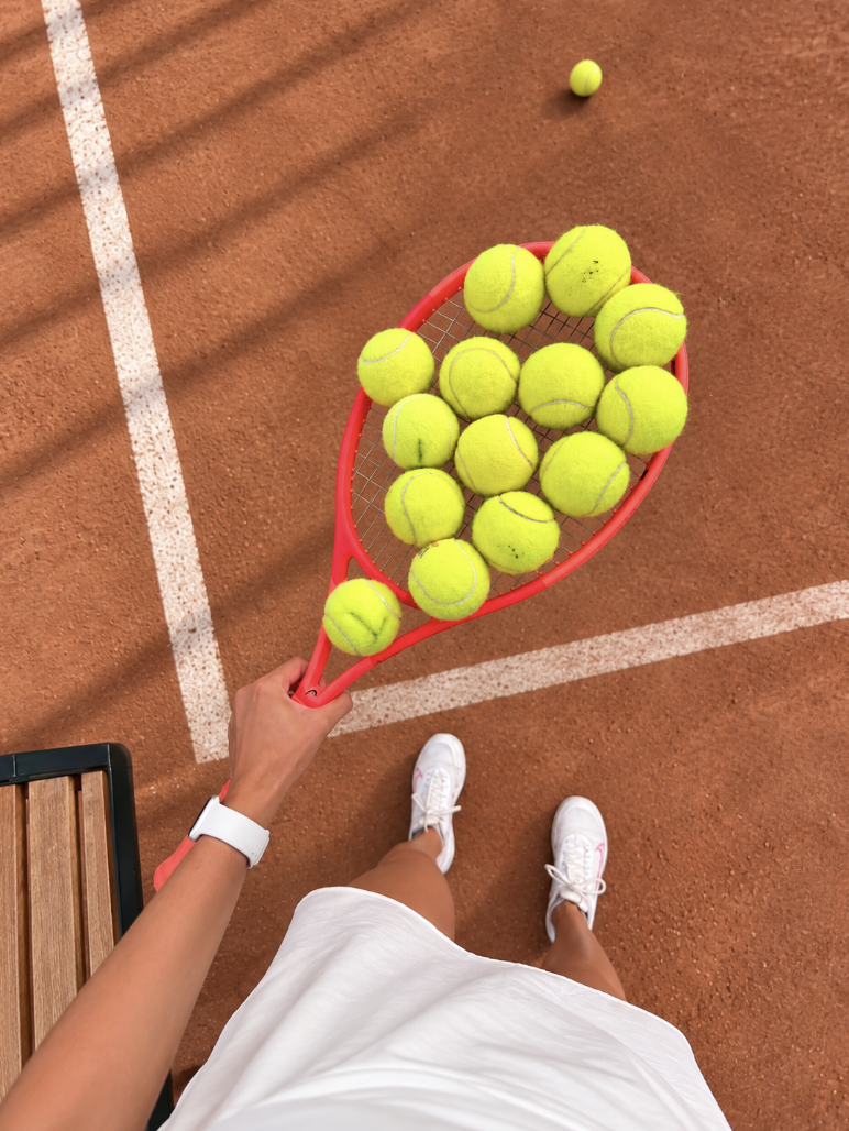 Tennisereket ja -pallid saviliivaväljakul