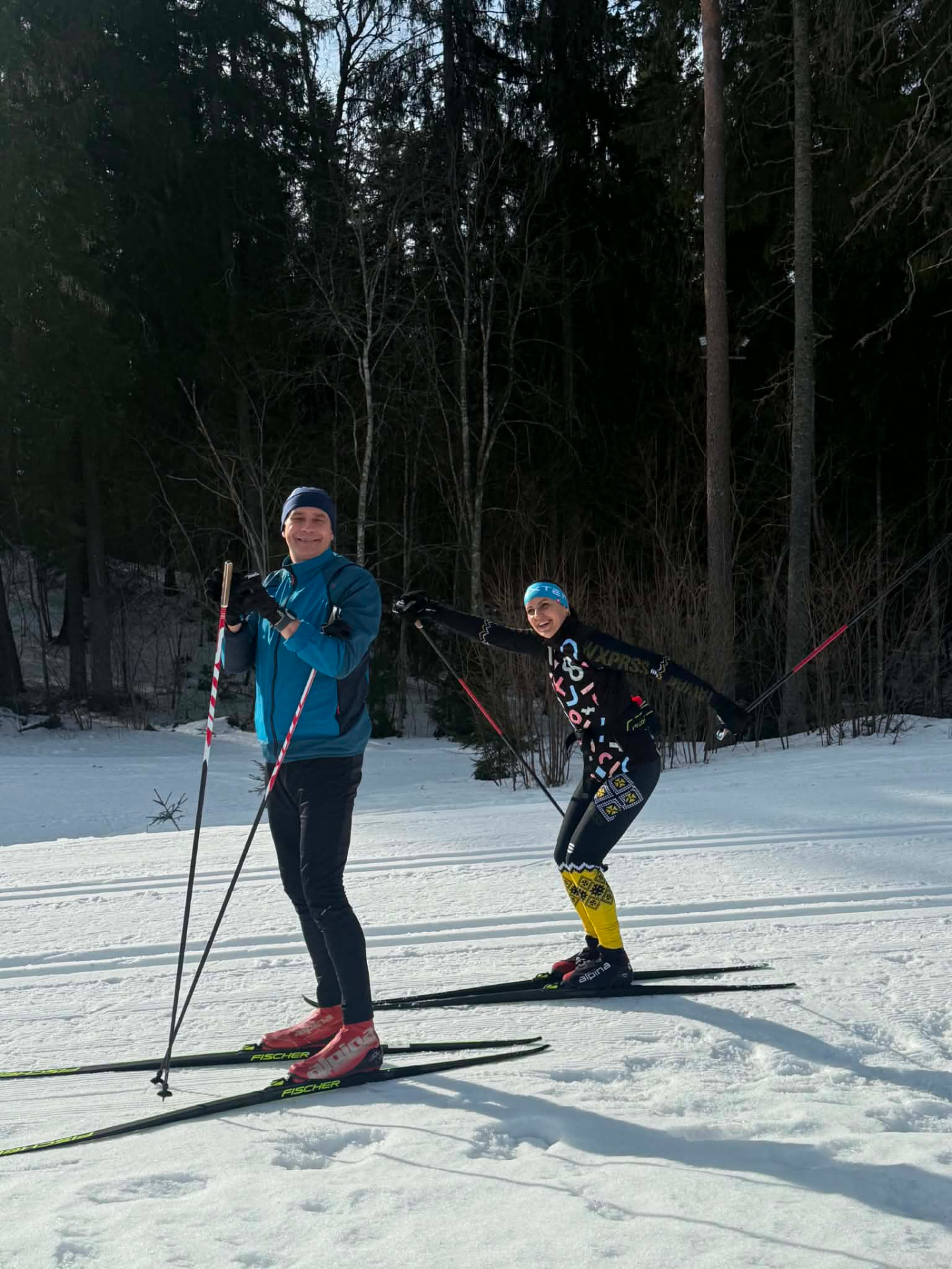 Kaks suusatajat lumisel metsarajal