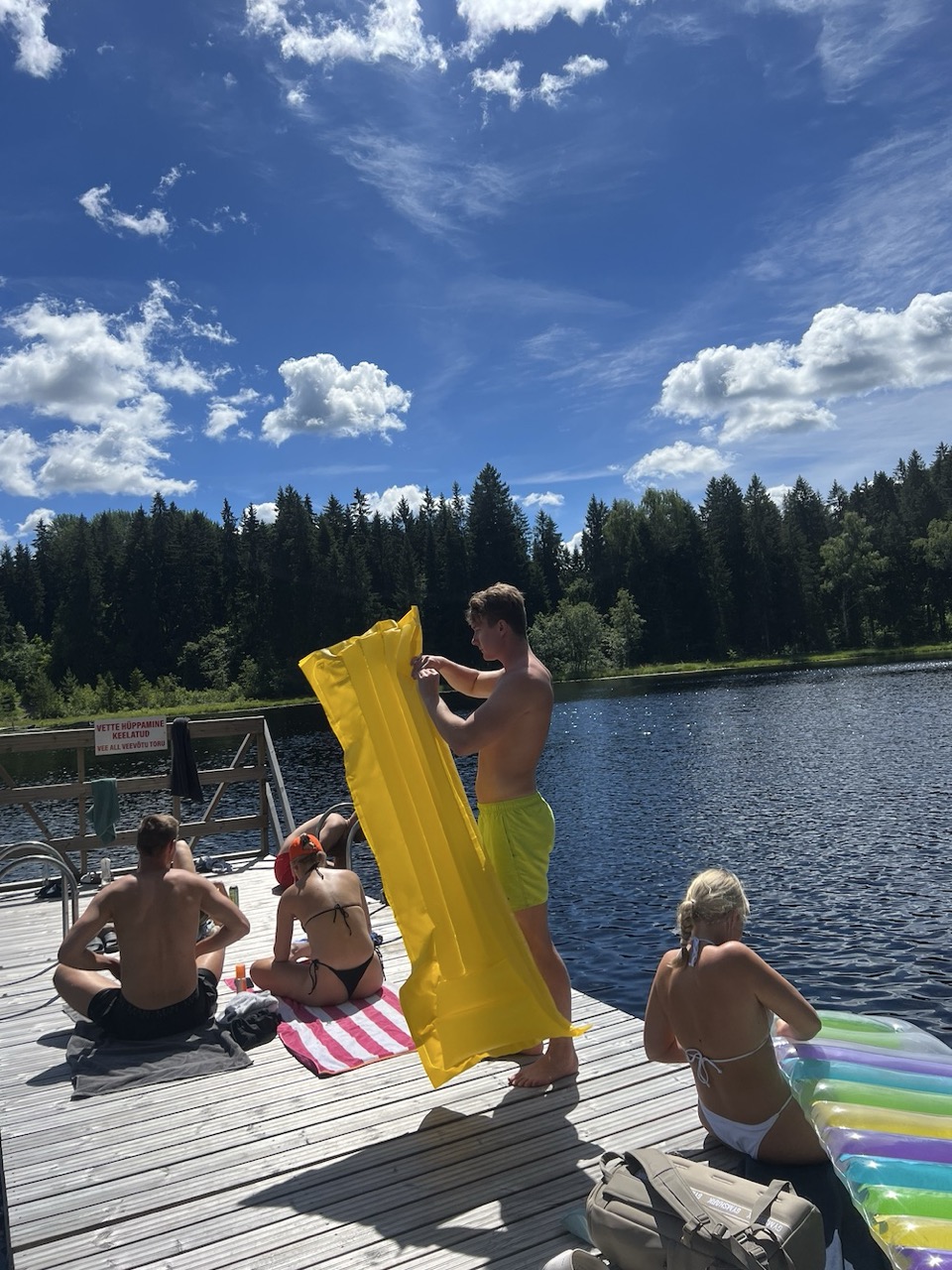 Seltskond lõõgastub ja mängib puidust kail järve ääres suvel